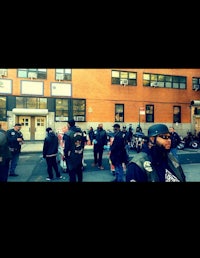 a group of people standing on a street in front of a building