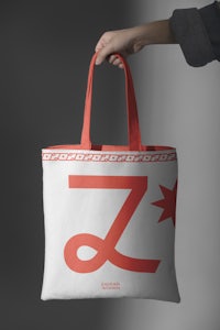 a hand holding a tote bag with the letter z on it