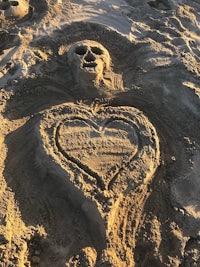 a heart shaped sand sculpture on the beach