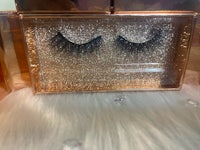 a pair of false lashes in a box on top of a furry surface