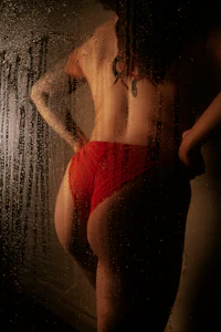 a woman in a red bikini standing in front of a window