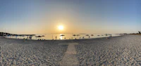 a group of people on a beach with umbrellas