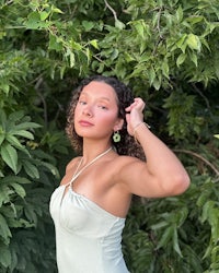 a woman in a green dress posing in the woods