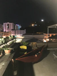a hammock on a rooftop with a view of the city