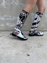 a woman wearing a pair of black and white rain boots