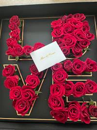 a box of red roses in a black frame