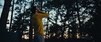 a man standing in the woods at dusk