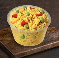 a bowl of rice with peas and carrots in it