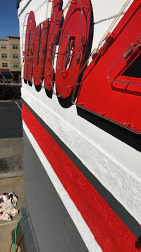 a red and white sign is painted on the side of a building
