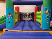 a large inflatable bouncer with a clown and balloons