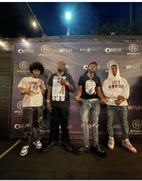 a group of young men standing in front of a banner