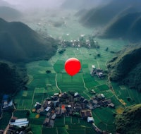 a red balloon in the sky over a village