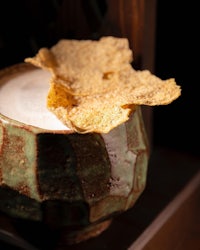 a cup with a cracker sitting on top of it