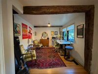a room with a desk, chairs and a rug