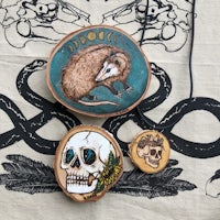 a necklace with a skull and an opossum on it