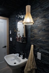 a bathroom with black walls and a wooden sink