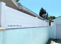 a white fence with a sign on it