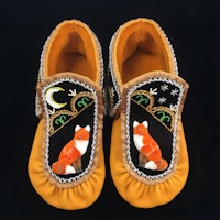 a pair of moccasins with foxes on them