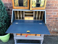 a blue and gold secretary desk with drawers