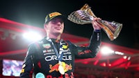 a red bull racing driver holding up a trophy
