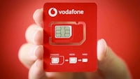 a person holding a vodafone sim card