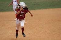 a softball player running on base during a game