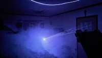 a blue light is shining on a table in a dark room
