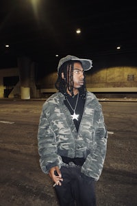 a young man wearing purple tie dye pants sitting on steps
