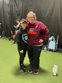 a woman is posing for a picture with a softball player