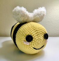 a crocheted bee stuffed animal sitting on a table