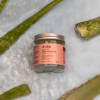 a jar of aloe vera gel sitting on top of water
