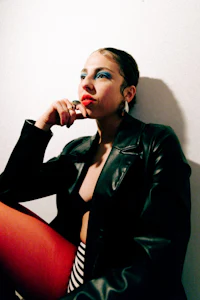 a woman wearing a black jacket and red tights