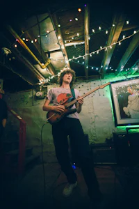 a man playing a guitar in a dark room