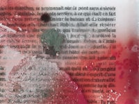 a close up of a book with red paint on it