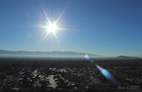 the sun is shining in the sky over a city