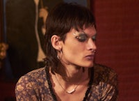 a woman sitting in a room with a painting on the wall