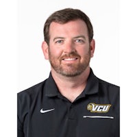 a man in a black polo with a beard