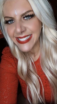 a woman with long blonde hair smiling for the camera