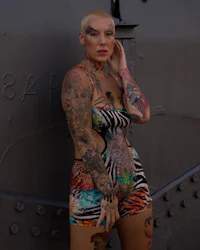 a woman with tattoos posing in front of a ship