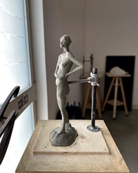 a statue of a woman on a table in a studio