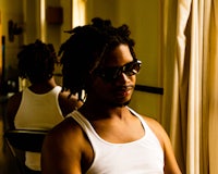 a man with dreadlocks sitting in a chair