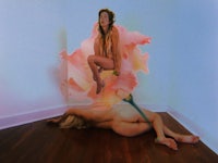 a woman is laying on the floor with a flower on her head