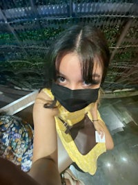 a woman wearing a mask and taking a selfie