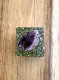an amethyst crystal on top of a wooden table