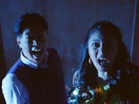 a man and a woman standing in a dark room