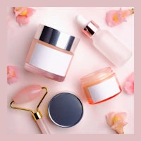 a variety of beauty products on a pink background