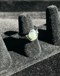 a silver ring with a green stone on top