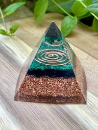 a green and brown pyramid on top of a wooden table