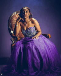 a woman in a purple dress sitting on a chair