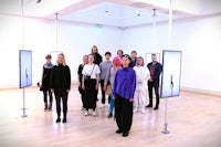 a group of people standing in an art gallery